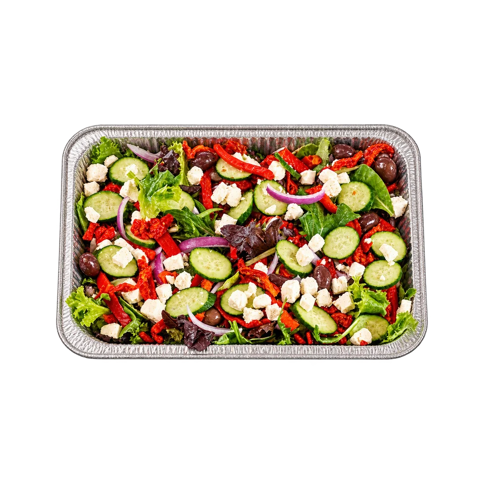 Greek salad with greens, cucumber, tomatoes, olives and feta in a foil catering tray